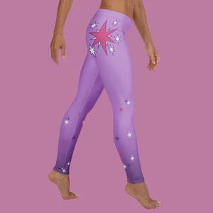 Può includere: Leggings color lavanda con effetto sfumato, con un grande disegno a stella rosa sulla gamba sinistra e piccoli accenti di stelle. I leggings hanno una vita alta e un design aderente.