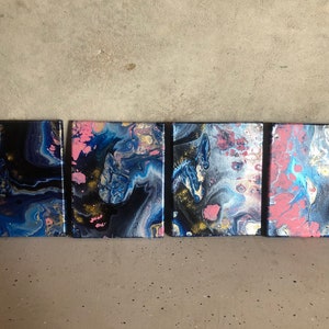 Puede incluir: Cuatro lienzos cuadrados de arte abstracto con pintura acrílica fluida. Las pinturas presentan una mezcla de colores que incluyen azul marino, negro, rosa, dorado y blanco. La obra de arte tiene un efecto marmoleado, creando una estética única y moderna.