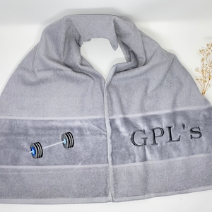 May include: Gray towel with a black barbell and the text "GPL'S" embroidered on it.