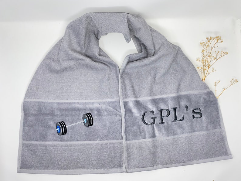 May include: Gray towel with a black barbell and the text "GPL'S" embroidered on it.
