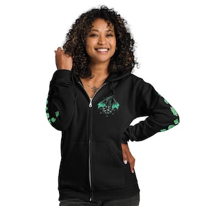 Könnte beinhalten: Schwarzer Kapuzenpullover mit Reißverschluss, auf dem sich ein grüner Drache auf der Vorderseite und grüne Würfel auf den Ärmeln befinden. Der Drache hat grüne Flügel und ist von Würfeln umgeben. Der Hoodie hat einen Reißverschluss und eine Kapuze.