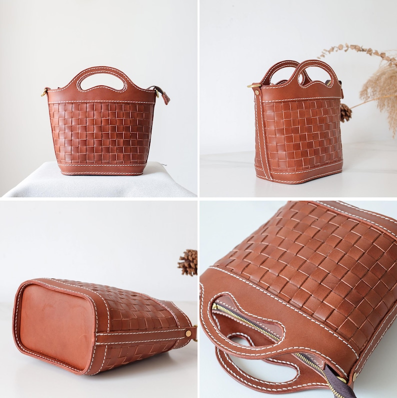 Puede incluir: Un bolso de mano de cuero marr&oacute;n con un dise&ntilde;o de cesta tejida. El bolso tiene dos asas y un cierre de cremallera. Las costuras blancas acent&uacute;an los bordes. El bolso mide aproximadamente 23 cm de alto y 20 cm de ancho.