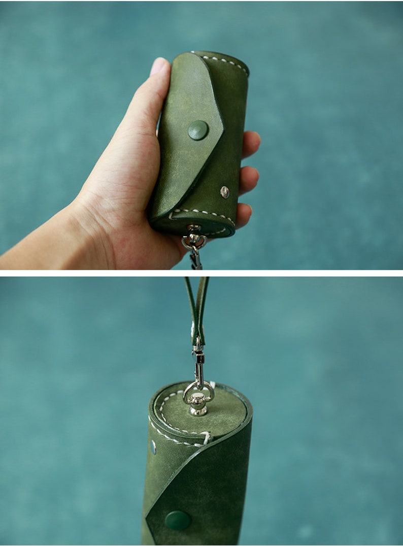 May include: A green leather key chain with a cylindrical pouch and a metal clasp. The pouch has a flap that closes with a button.