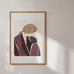 May include: Abstract art print of a person in a burgundy suit with a bird on their shoulder. The print is framed in a light wood frame.