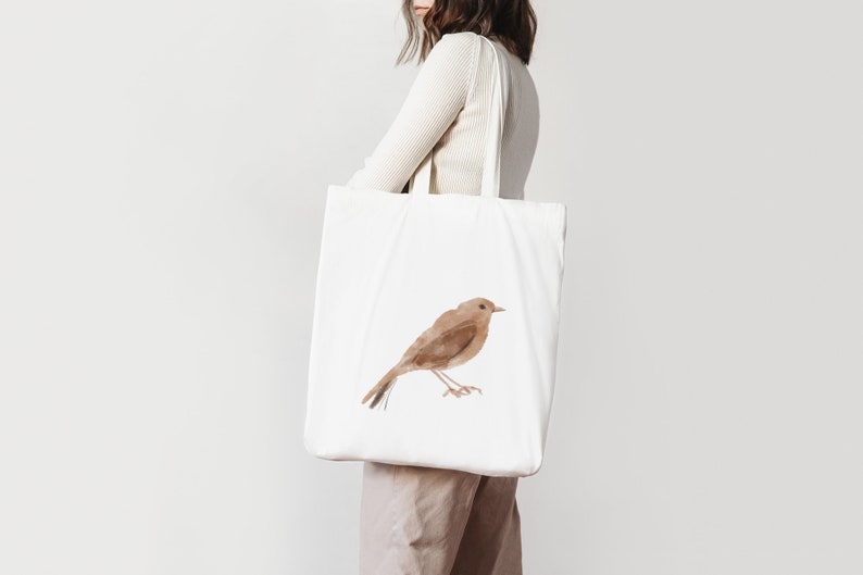 K&ouml;nnte beinhalten: Eine wei&szlig;e Einkaufstasche mit einer braunen Aquarell-Vogel-Illustration. Die Tasche hat zwei lange Henkel.
