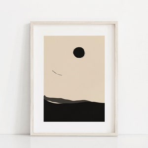 May include: A framed abstract print with a black circle and a thin black line against a beige background. The bottom of the print is black with a dark gray line.