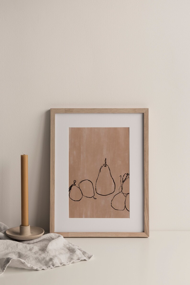 May include: A framed print of a line drawing of pears and other fruit on a light brown background. The frame is light wood.