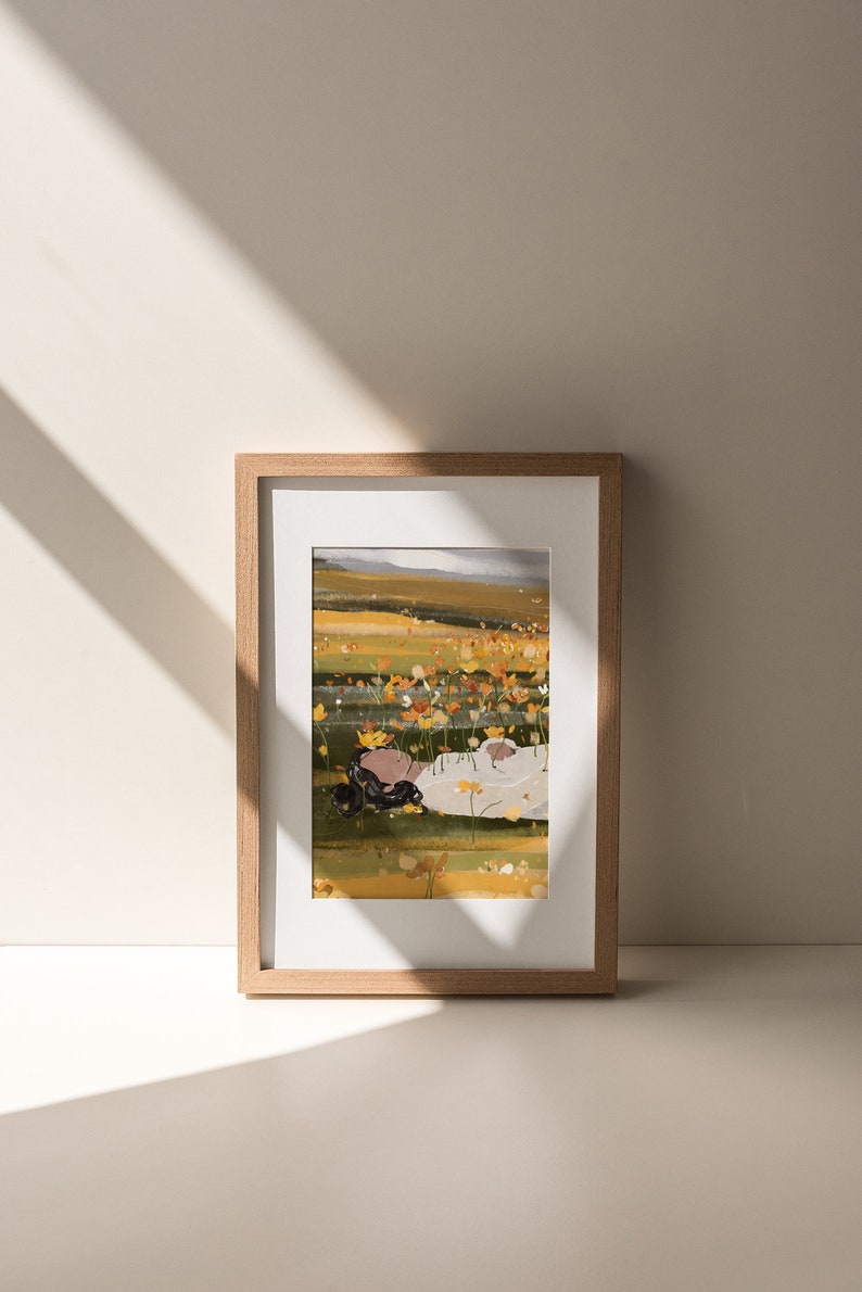K&ouml;nnte beinhalten: Eine gerahmte Illustration einer Person, die in einem Feld mit gelben Blumen liegt. Die Person tr&auml;gt ein wei&szlig;es Hemd und hat lange dunkle Haare. Der Hintergrund ist ein Feld mit gelben Blumen und einem blauen Himmel.