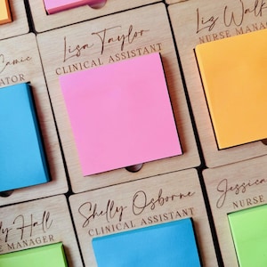 May include: A wooden desk organiser with individual slots for sticky notes. Each slot has a personalised name and job title, such as "Jamie, Coordinator", "Lisa Taylor, Clinical Assistant", "Shelly Osborne, Clinical Assistant", "Liz Walker, Nurse Manager", and "Jessica, Nurse".