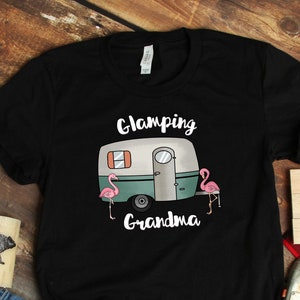 May include: Black t-shirt with the text "Glamping Grandma" and a graphic of a vintage camper with pink flamingos.