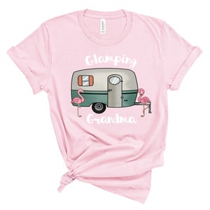 May include: Pink t-shirt with a white camper van graphic and the text "Glamping Grandma" and two pink flamingos.