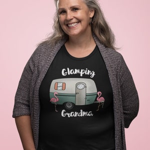 May include: Black t-shirt with a white camper van graphic and the text "Glamping Grandma" with two pink flamingos on either side of the camper. The text "Someday Designs Co." is at the bottom of the shirt.