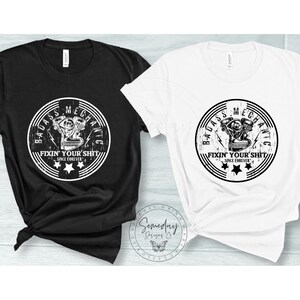 May include: Two t-shirts with a distressed white graphic of a motorcycle engine with the text "Badass Mechanic Fixin' Your Shit Since Forever" in a circle.