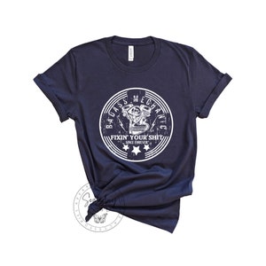 May include: Navy blue t-shirt with a white graphic of a motorcycle engine and the text "Badass Mechanic Fixin' Your Shit Since Forever".