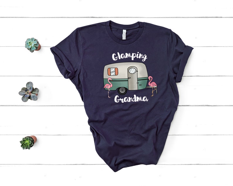 May include: Navy blue t-shirt with a white camper van and pink flamingos graphic. The text "Glamping Grandma" is printed below the camper van.