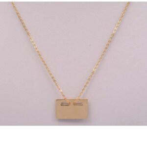 May include: A gold chain necklace with a rectangular pendant.