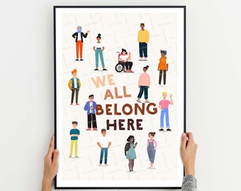May include: A framed print with a white background and a colorful illustration of people of different races, genders, and abilities. The text "We all belong here" is written in brown letters.