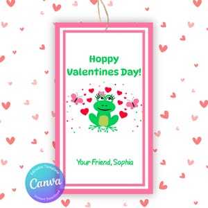 May include: A Valentine's Day gift tag with a pink border and a white interior. The tag features a green frog with a flower crown, red hearts, and butterflies. Text reads "Hoppy Valentines Day!" and "Your Friend, Sophia."