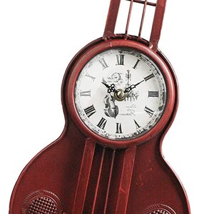 May include: Red metal clock shaped like a guitar with Roman numeral clock face and a small image of a guitar player on the face.