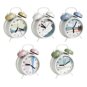 May include: Five white alarm clocks with different colored bells and landscape-themed clock faces. The bells are yellow, white, blue, pink, and green. The clock faces feature mountain and nature scenes.