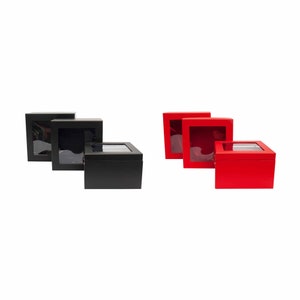 May include: Three black and three red square boxes with clear lids. The boxes are arranged in two rows, with the black boxes on the top row and the red boxes on the bottom row.