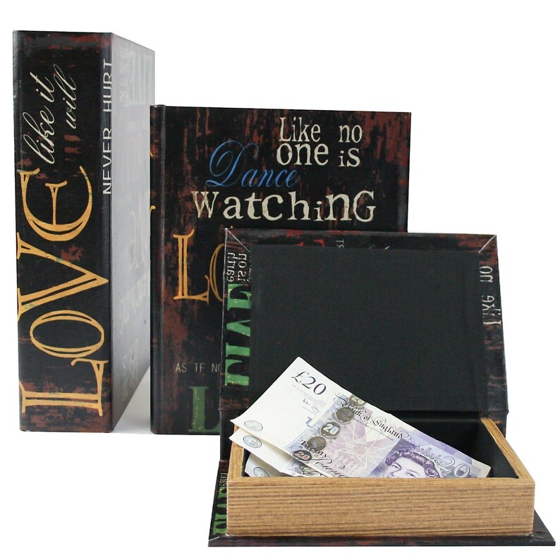 May include: Three decorative book-shaped boxes with hidden compartments. The boxes are black with gold and colorful text. The text on the boxes reads "LOVE like it will NEVER HURT", "Like no one is Dance Watching", and "Like no".