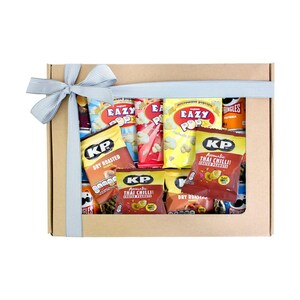 May include: A brown cardboard box filled with a variety of snacks, including bags of popcorn, peanuts, and chips. The box is tied with a blue and white ribbon.