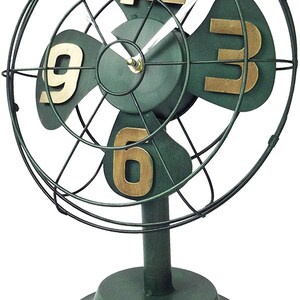 May include: A green metal fan-shaped clock with gold numbers. The clock has a black metal frame and a round base.