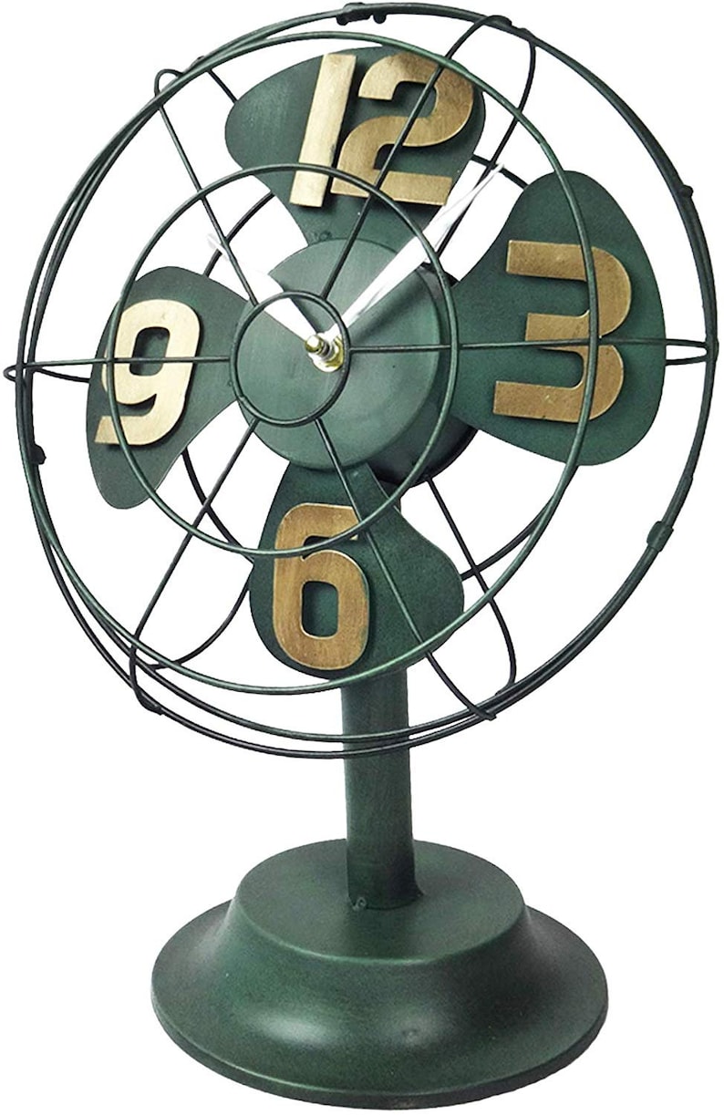 May include: A green metal fan-shaped clock with gold numbers. The clock has a black metal frame and a round base.
