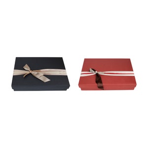 May include: Two gift boxes with ribbon bows. One box is black with a beige ribbon and the other is red with a brown ribbon.