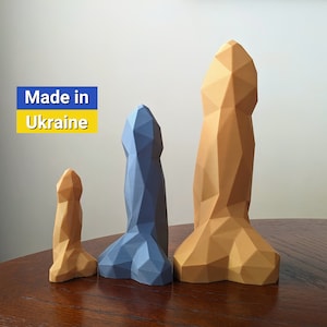May include: Three geometrically shaped sculptures, one blue, one yellow, and one orange, made in Ukraine. The sculptures are arranged in order of size, with the largest sculpture on the right and the smallest on the left.