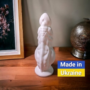 May include: White ceramic sculpture of a human figure with a textured surface. The sculpture is standing on a wooden surface. The text "Made in Ukraine" is visible in the image.