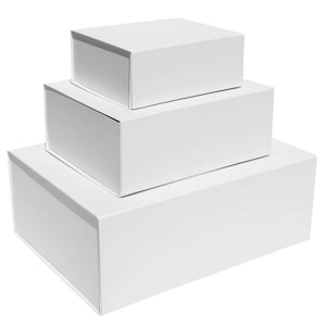 May include: Three white cardboard boxes stacked on top of each other. The boxes are all the same shape and size, but the top box is slightly smaller than the bottom two.