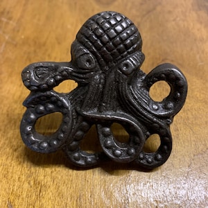 May include: A black cast iron octopus figurine with detailed tentacles and a textured head.