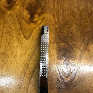 May include: A silver cabinet pull with a diamond-shaped pattern. The pull is rectangular and has a smooth, polished finish.