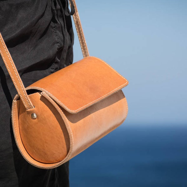 Women's small leather barrel crossbody saddle purse, handmade in Greece from full grain cowhide leather in natural leather colour - KYANIA