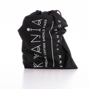 May include: Black drawstring bag with white text that reads "KYANIA HANDMADE LEATHER SANDALS & BAGS WWW.KYANIA.GR"