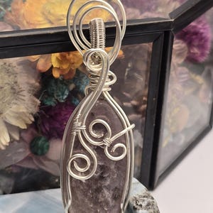 May include: A white ceramic mug with a black handle and the text "But First, Coffee" in a bold, black font. The mug is set against a neutral background, highlighting its simple design.