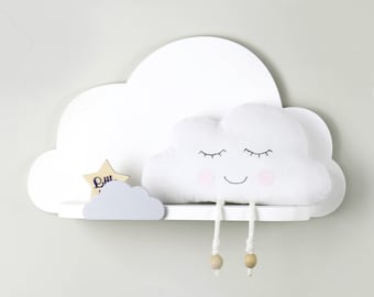 May include: White cloud-shaped shelf with a white plush cloud with a smiling face and closed eyes hanging from the shelf. The cloud has two wooden bead strings hanging from it. A small wooden star is on the shelf.