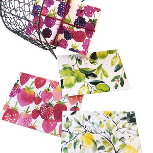 May include: A wire basket holds a stack of cards with watercolor fruit designs. The cards feature strawberries, lemons, and blackberries. The cards are tied with a burgundy ribbon. The basket is black.