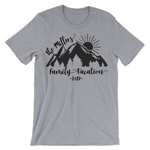 May include: A gray t-shirt with a black mountain silhouette, sun, and trees. The text "The Millers Family Vacation -2019- " is printed on the shirt.