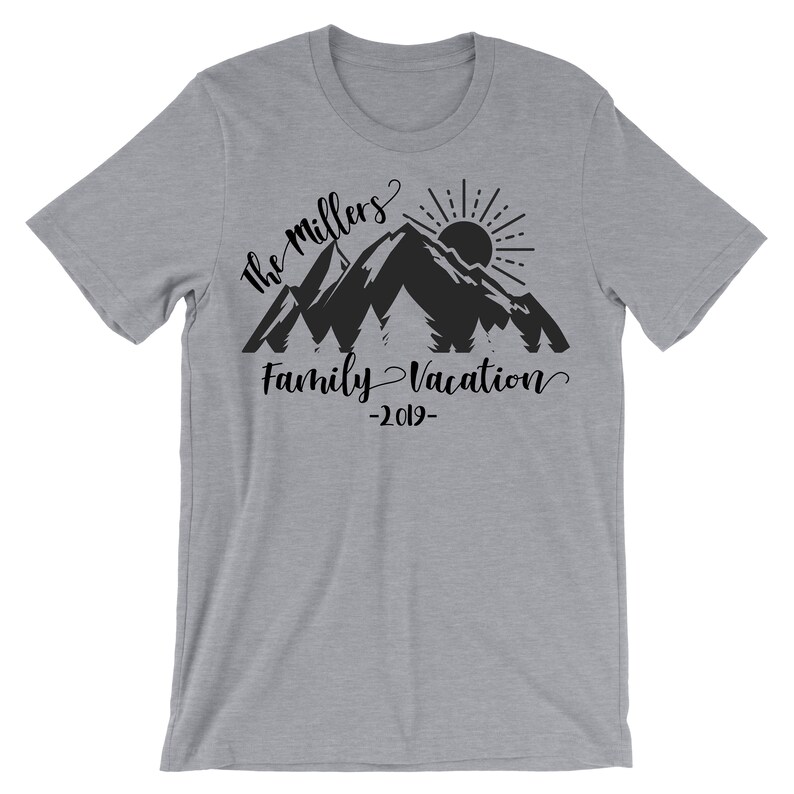 May include: A gray t-shirt with a black mountain silhouette, sun, and trees. The text "The Millers Family Vacation -2019- " is printed on the shirt.