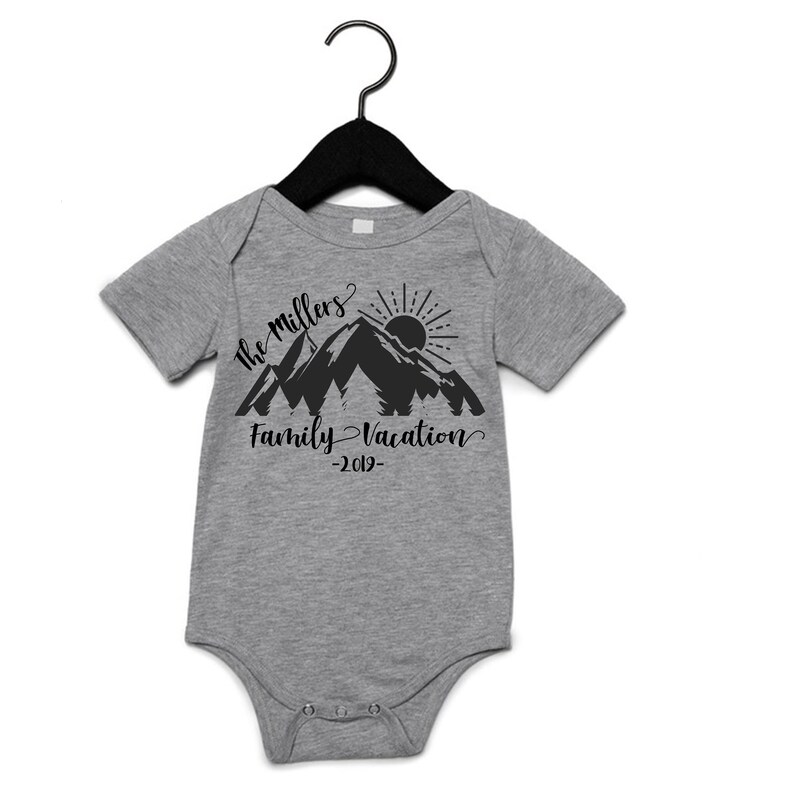 May include: Gray short-sleeved bodysuit with a black mountain silhouette, sun, and the text "The Millers Family Vacation -2019-"