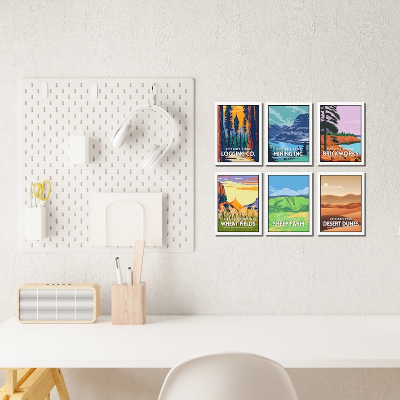 May include: Six vintage-style travel posters with colorful illustrations and text. The posters are framed and hung on a white wall. The posters feature scenes of a logging company, a mining company, brickworks, wheat fields, a sheep farm, and desert dunes.