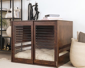 Könnte beinhalten: Eine dunkelbraune Hundebox aus Holz mit Schiebetüren mit horizontalen Lamellen und transparenten Paneelen. Die Box hat ein eingebautes Bett und ist so konzipiert, dass sie sich in die Wohnkultur einfügt. Die Box steht auf einem weißen Teppich.