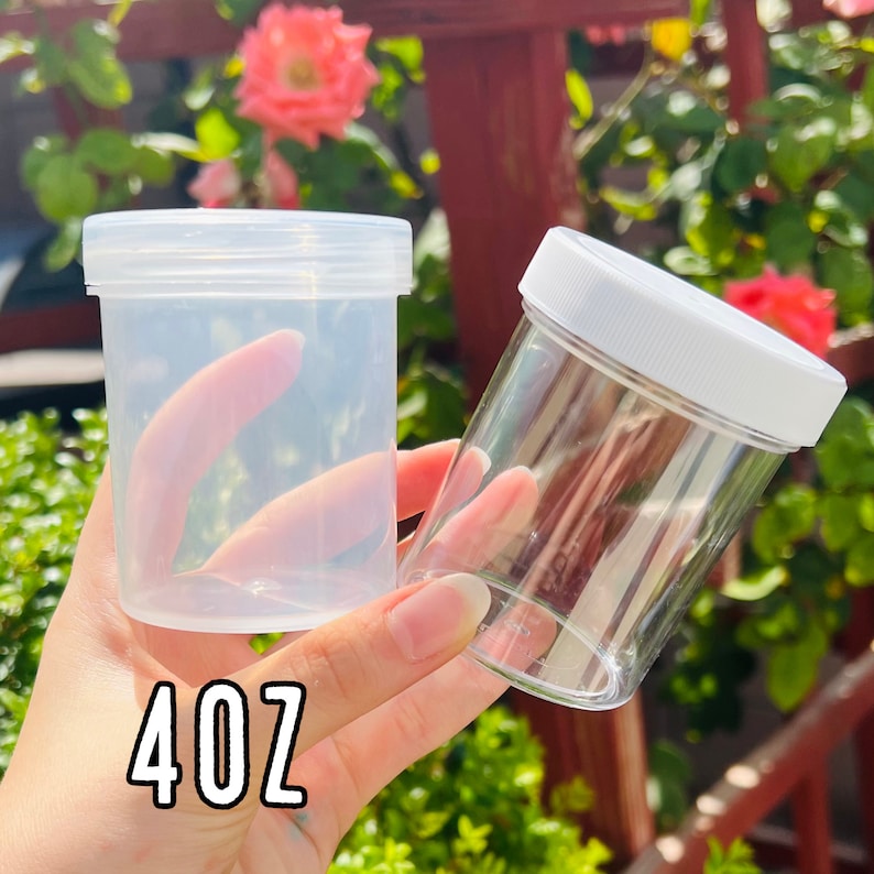 K&ouml;nnte beinhalten: Zwei durchsichtige Plastikgl&auml;ser mit wei&szlig;en Deckeln. Das gr&ouml;&szlig;ere Glas ist mit "4 oz" beschriftet.