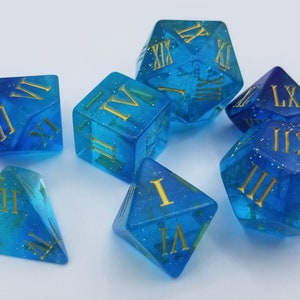 May include: Set of seven blue and gold dice with Roman numeral markings. The dice are translucent and have a glittery finish.