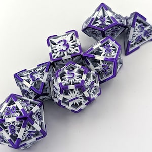 May include: A set of seven purple and white metal dice with a sunburst design. The dice are numbered 1 through 6, and the 20-sided die has numbers 1 through 20.