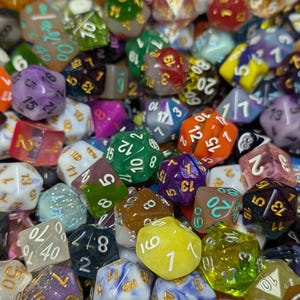 May include: A collection of polyhedral dice in various colors, including green, purple, orange, and blue. The dice are of different shapes and sizes, with numbers clearly visible on each face. Ideal for tabletop games.