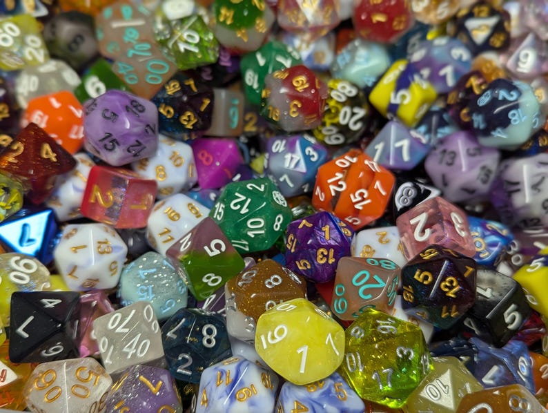 May include: A collection of polyhedral dice in various colors, including green, purple, orange, and blue. The dice are of different shapes and sizes, with numbers clearly visible on each face. Ideal for tabletop games.